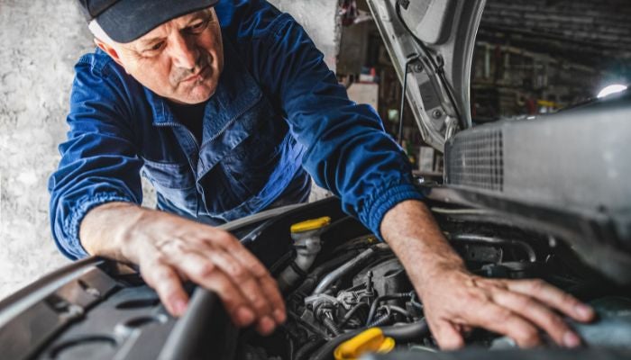 Mechanic fixing car engine